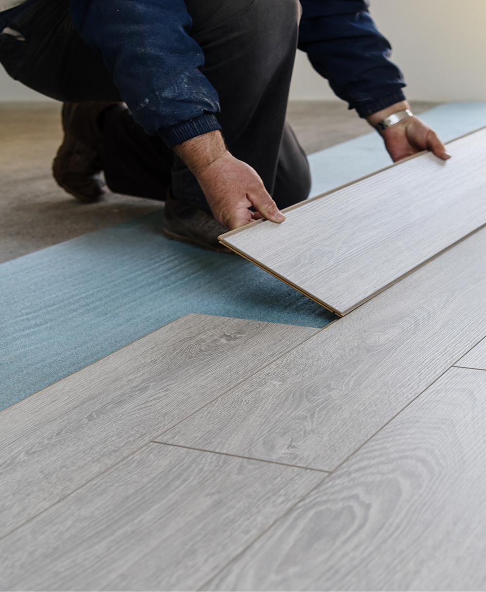 Worker laying wooden floorboards