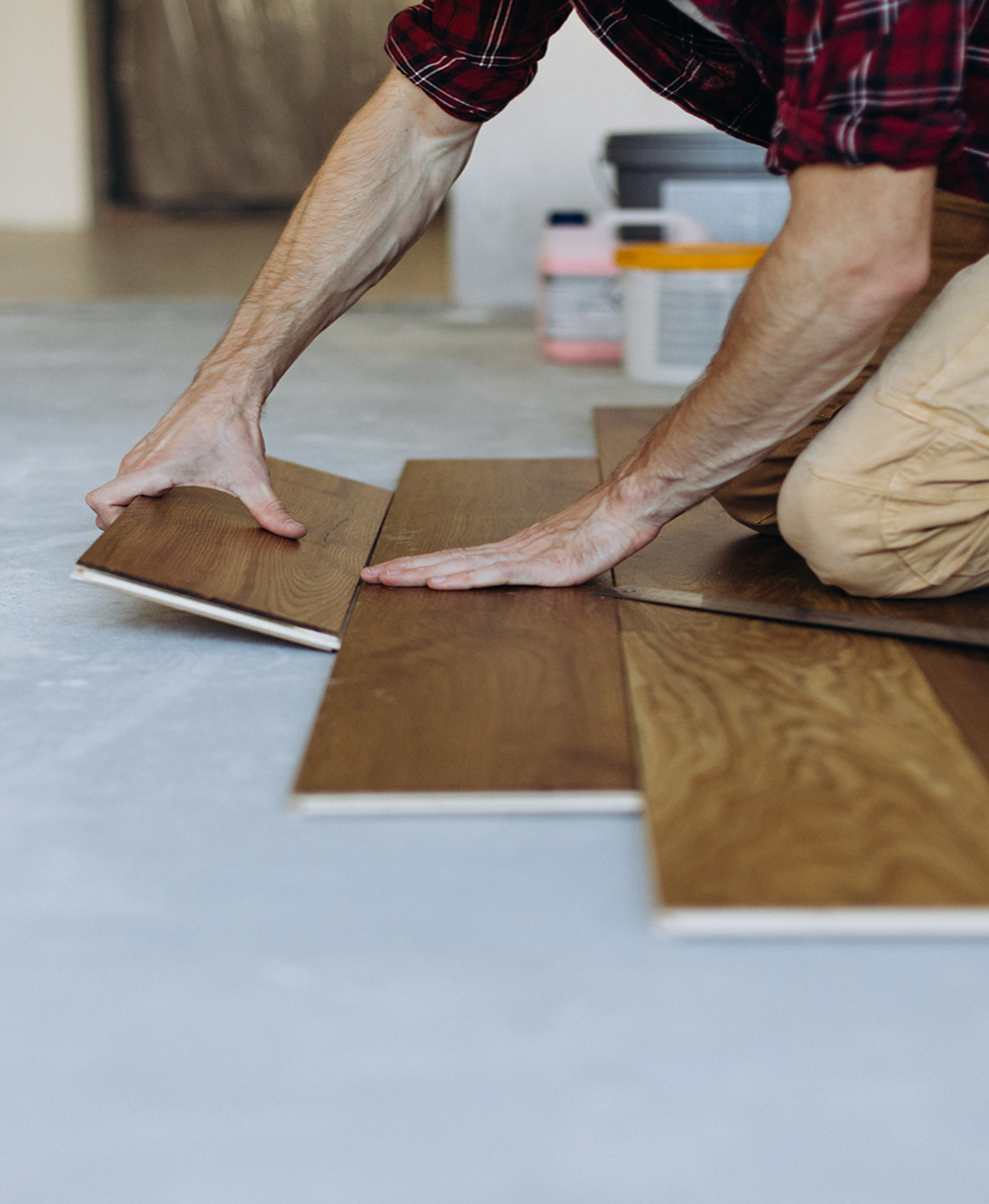 Person fitting hardwood floor pieces
