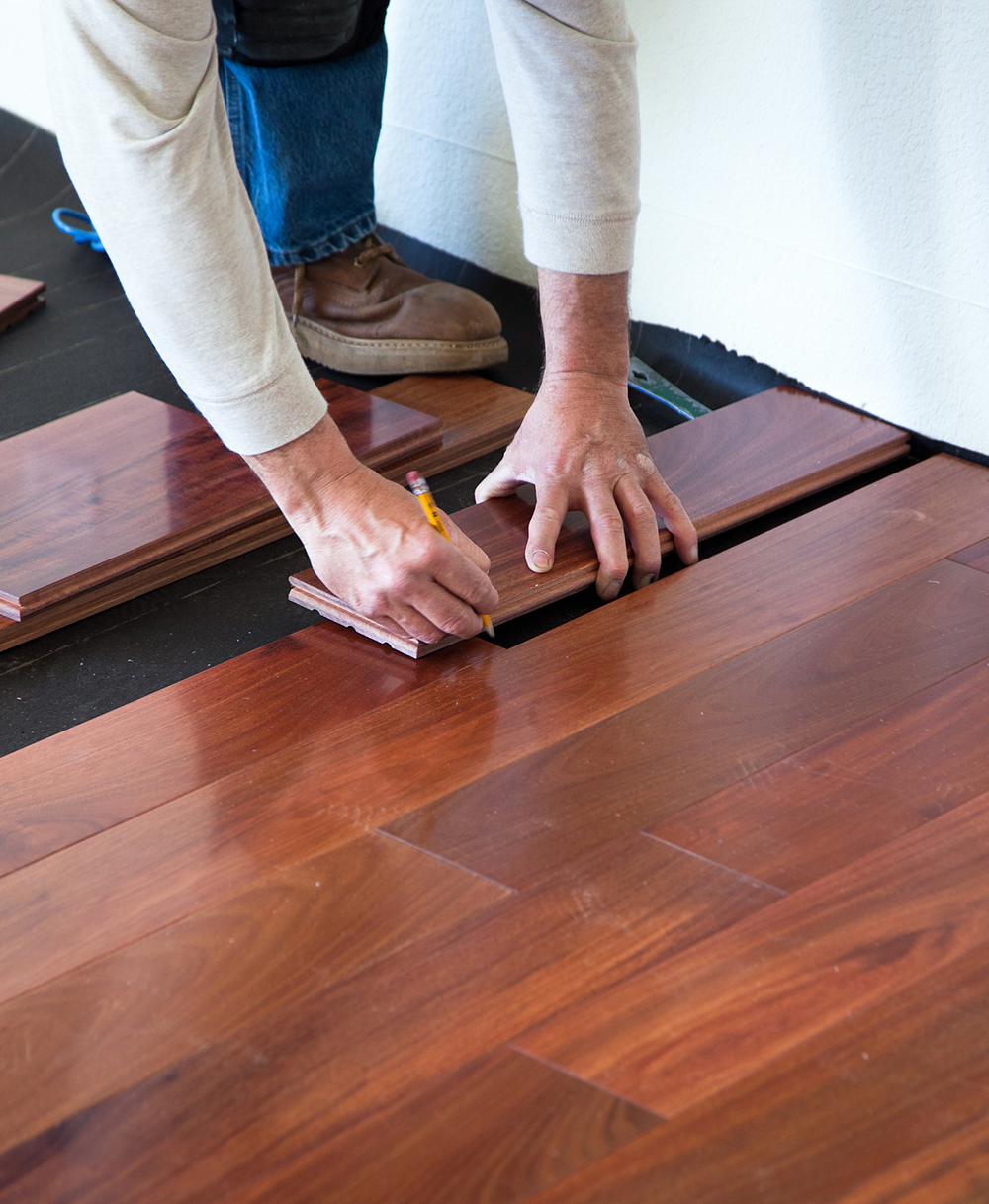 Person measuring wooden floorboards