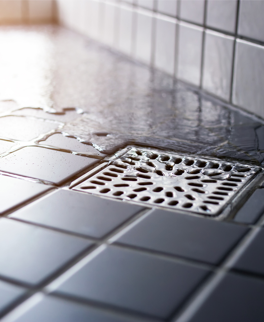 Bathroom tiles with water and drain.
