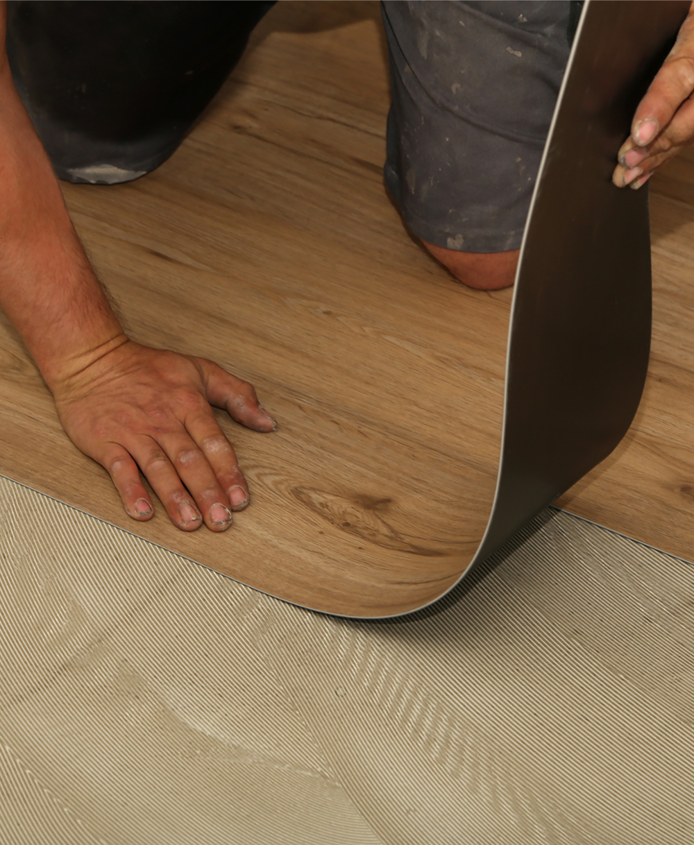Worker fitting vinyl floor sheet