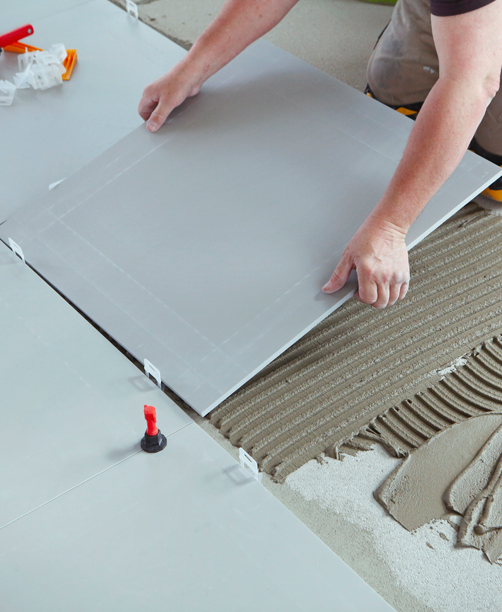 Laying large floor tiles with adhesive